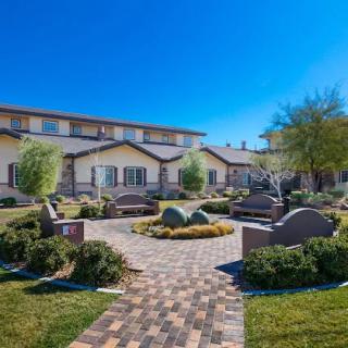 Beautiful residential complex with landscaped garden and pathway under a clear blue sky.