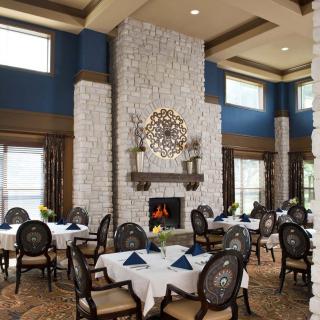 An elegant dining room featuring a large stone fireplace and stylish decor.