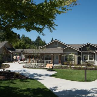 A residential building surrounded by a landscaped garden and pathway.