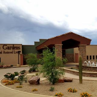 A building entrance with desert landscaping under a cloudy sky.