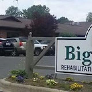 Entrance to a rehabilitation facility with a sign displaying its name.