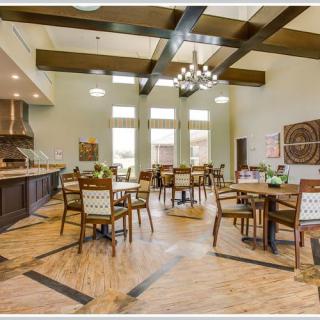 A spacious and elegantly designed dining area with wooden furniture, a chandelier, and decorative elements.