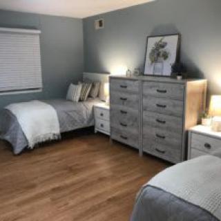A tidy bedroom with twin beds, grey tones, and minimalist decor.