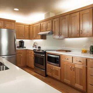 A modern kitchen with wooden cabinets and stainless steel appliances.