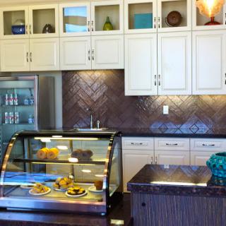 A modern bakery kitchen featuring a display case filled with pastries and elegantly designed cabinetry.