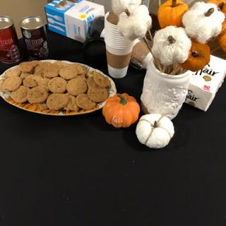 A cozy autumn table setting featuring delicious cookies, pumpkins, and festive decorations.