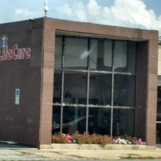 A view of a medical clinic building with large windows and landscaping in front.