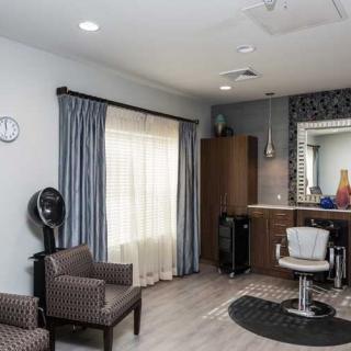 A modern hair salon with stylish furnishings and a large mirror.