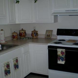 A cozy kitchen with white cabinets and a black stove.