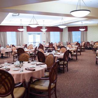 A spacious dining room with elegantly set tables and comfortable seating.