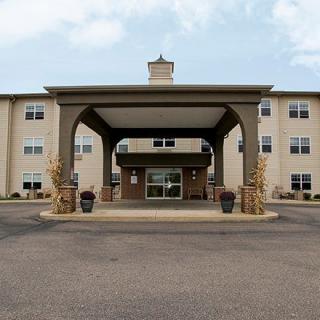 Main entrance of a hotel building with an awning and brick facade.