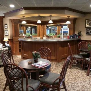 A cozy interior lounge featuring wooden furniture and a welcoming bar area.