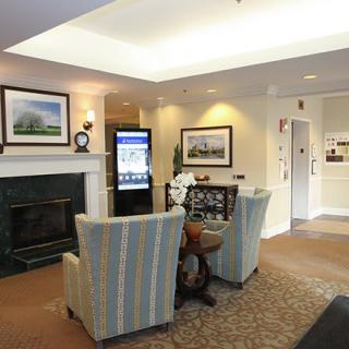 A cozy lobby with armchairs, a fireplace, and elegant decor.