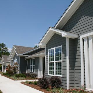 A row of modern suburban homes with neatly maintained gardens and walkways.