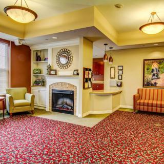 A cozy living room with a fireplace, comfortable seating, and warm lighting.