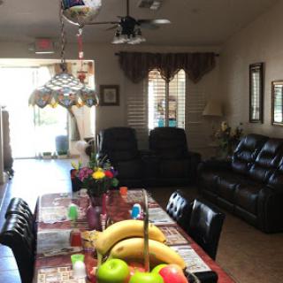 A cozy living space featuring a dining table adorned with fruit and comfortable seating.