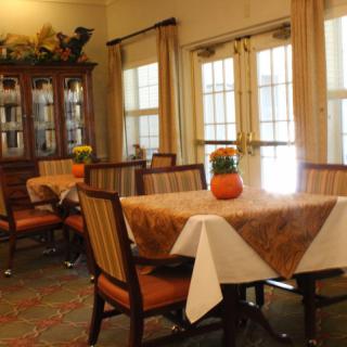 A cozy dining area with neatly arranged tables and chairs, adorned with decorative items.