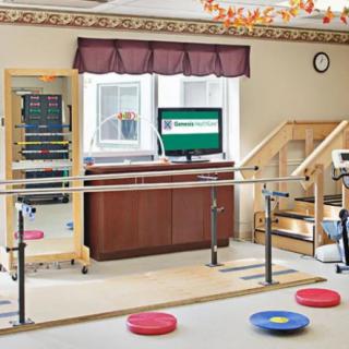 A physical therapy room equipped with parallel bars, exercise pads, a mirror, stairs, and a television.