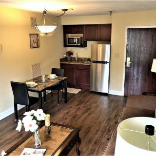A modern apartment interior featuring a cozy living room and kitchen area with dining setup.