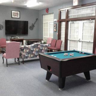 A cozy game room with a pool table and seating area.