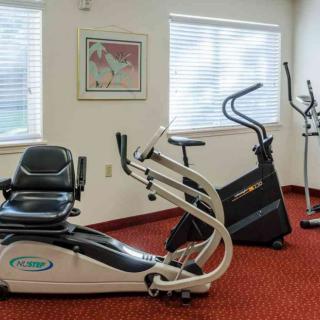A fitness room with stationary exercise equipment including a bike and elliptical machine.