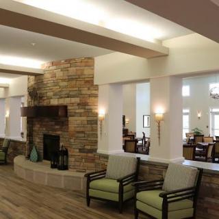 A modern living room interior with a stone fireplace and comfortable seating.