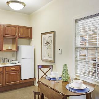 Cozy kitchen and dining area with wooden cabinets and a small table set for two.