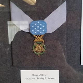 A framed display of the Medal of Honor awarded to Stanley T. Adams.