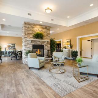 A modern living room with a cozy fireplace, stylish furniture, and warm lighting.