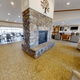 A spacious modern interior featuring a stone fireplace and comfortable seating areas.