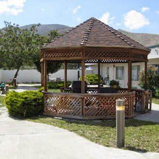 A charming wooden gazebo nestled in a well-kept garden, perfect for relaxation and outdoor gatherings.