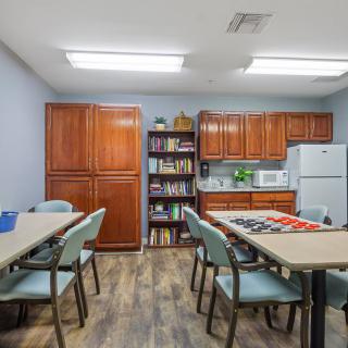 A well-organized break room with tables, chairs, and kitchen appliances.