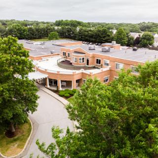 Aerial view of a modern healthcare facility surrounded by lush greenery.