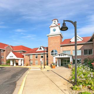 A charming residential building featuring a clock tower and landscaped surroundings.