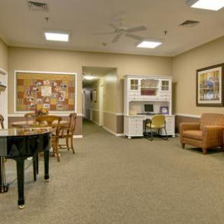 A cozy living room with a piano and comfortable seating.