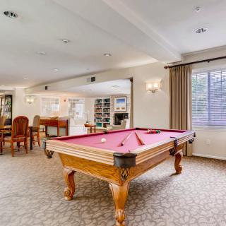 A spacious game room with a pool table and dining area.