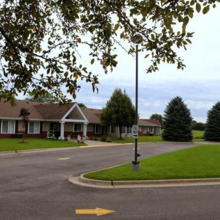 A suburban residential area with houses, a driveway, and surrounding greenery.