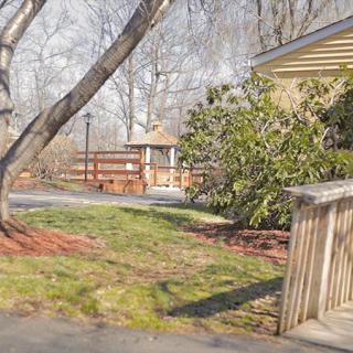 A peaceful backyard scene with a gazebo, trees, and a wooden fence.