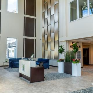 A modern lobby with a reception desk, seating area, and decorative elements.
