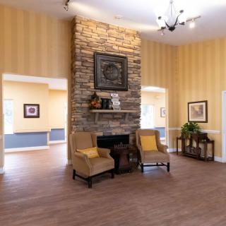 A cozy living room with a stone fireplace and comfortable seating.