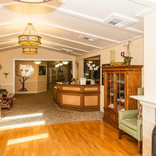 A cozy reception area featuring a wooden desk, comfortable seating, and warm lighting.