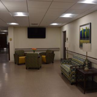 A quiet waiting area with chairs and a television on the wall.