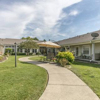 A peaceful residential courtyard with a walkway, garden, and patio area.