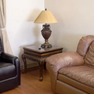 A cozy living room corner with a lamp on a wooden coffee table between two sofas.