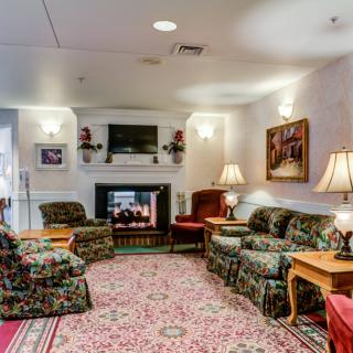 A cozy living room with a fireplace, sofas, armchairs, and various decor elements.