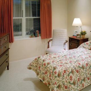 A cozy bedroom with floral bedding and soft lighting.