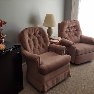A cozy living room setup featuring two plush armchairs and a lamp.