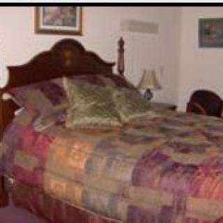 A cozy bedroom with a large bed and decorative pillows.