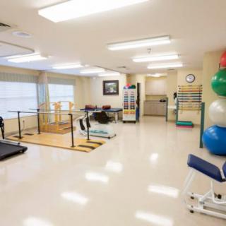 A spacious rehabilitation center equipped with various exercise and therapy equipment.