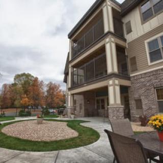 A modern apartment building surrounded by fall foliage and well-maintained landscaping.